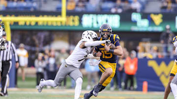 Nov 8, 2025; Morgantown, West Virginia, USA; West Virginia Mountaineers quarterback Scotty Fox Jr. (15) runs with the ball and is tackled by Colorado Buffaloes defensive back Tawfiq Byard (7) during the fourth quarter at Milan Puskar Stadium. Mandatory Credit: Ben Queen-Imagn Images