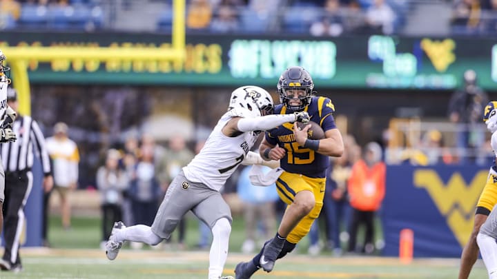 Nov 8, 2025; Morgantown, West Virginia, USA; West Virginia Mountaineers quarterback Scotty Fox Jr. (15) runs with the ball and is tackled by Colorado Buffaloes defensive back Tawfiq Byard (7) during the fourth quarter at Milan Puskar Stadium. Mandatory Credit: Ben Queen-Imagn Images