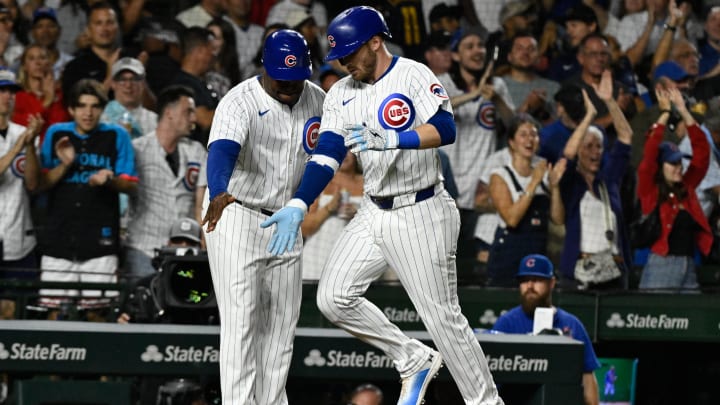 Chicago Cubs outfielder Ian Happ (8) high fives  third base coach Willie Harris (33) after  he hits a home run against the Milwaukee Brewers during the sixth inning at Wrigley Field on July 22.