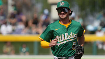 Mar 17, 2025; Mesa, Arizona, USA; Oakland Athletics shortstop Jacob Wilson (5) laughs after making a play against the Seattle Mariners in the third inning at Hohokam Stadium. Mandatory Credit: Rick Scuteri-Imagn Images