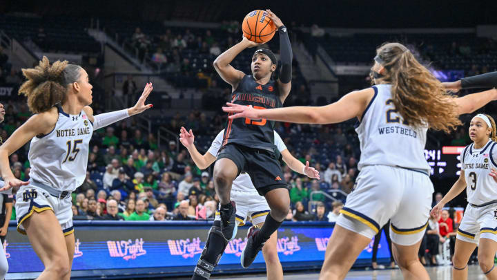 Jan 14, 2024; South Bend, Indiana, USA; Miami Hurricanes guard Lashae Dwyer (13) goes up for a shot as Notre Dame Fighting Irish forward Nat Marshall (15) and forward Maddy Westbeld (21) defend in the second half at the Purcell Pavilion. Mandatory Credit: Matt Cashore-USA TODAY Sports