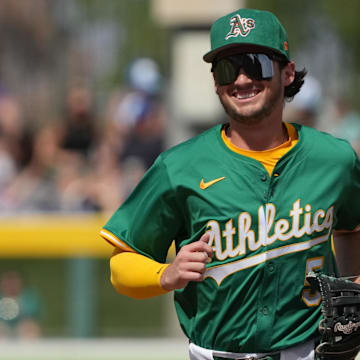 Mar 17, 2025; Mesa, Arizona, USA; Oakland Athletics shortstop Jacob Wilson (5) laughs after making a play against the Seattle Mariners in the third inning at Hohokam Stadium. Mandatory Credit: Rick Scuteri-Imagn Images
