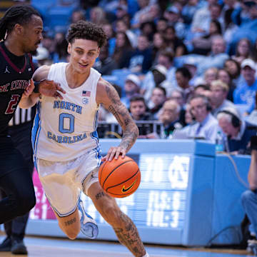 Nov 14, 2025; Chapel Hill, North Carolina, USA; North Carolina Tar Heels guard Kyan Evans (0) drives on North Carolina Central Eagles guard Dionte Johnson (2) during the second half at Dean E. Smith Center. 