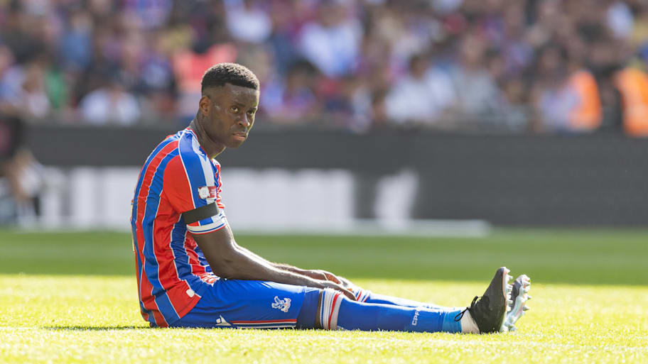Marc Guéhi sitting on the Wembley turf.