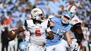 Nov 4, 2023; Chapel Hill, North Carolina, USA;  Campbell Fighting Camels quarterback Hajj-Malik Williams (6) looks to pass as North Carolina Tar Heels defensive lineman Beau Atkinson (12) pressures in the third quarter at Kenan Memorial Stadium. Mandatory Credit: Bob Donnan-Imagn Images