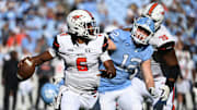 Nov 4, 2023; Chapel Hill, North Carolina, USA;  Campbell Fighting Camels quarterback Hajj-Malik Williams (6) looks to pass as North Carolina Tar Heels defensive lineman Beau Atkinson (12) pressures in the third quarter at Kenan Memorial Stadium. Mandatory Credit: Bob Donnan-Imagn Images