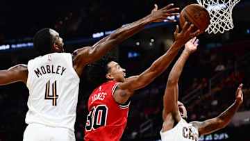 Oct 7, 2025; Cleveland, Ohio, USA; Chicago Bulls guard Tre Jones (30) drives to the basket between Cleveland Cavaliers forward Evan Mobley (4) and forward Jaylon Tyson (20) during the second half at Rocket Arena. Mandatory Credit: Ken Blaze-Imagn Images