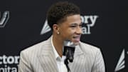 Jun 28, 2025; San Antonio, TX, USA; San Antonio Spurs first round draft pick Carter Bryant answers questions during press conference at Victory Capital Performance Center.