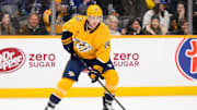 Jan 29, 2025; Nashville, Tennessee, USA;  Nashville Predators center Gustav Nyquist (14) skates with the puck against the Vancouver Canucks during the first period at Bridgestone Arena. Mandatory Credit: Steve Roberts-Imagn Images