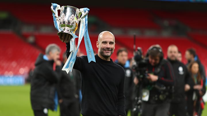 Manager of Manchester City, Pep Guardiola holds the trophy