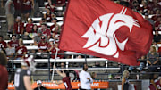 Sep 7, 2024; Pullman, Washington, USA; Washington State Cougars cheerleader carries the school flag against the Texas Tech Red Raiders in the second half at Gesa Field at Martin Stadium. Washington State Cougars won 37-16. Mandatory Credit: James Snook-Imagn Images