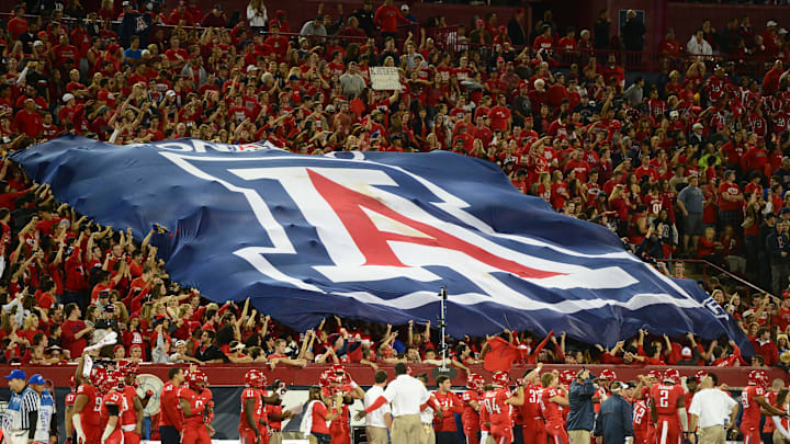 Nov. 23, 2012; Tucson, AZ, USA: Arizona Wildcats fans hold a flag in the grandstands in the second half against the Arizona State Sun Devils at Arizona Stadium. The Sun Devils defeated the Wildcats 41-34. Mandatory Credit: Mark J. Rebilas-Imagn Images