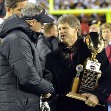 November 26, 2011; Kansas City, MO, USA; Kansas City Chiefs owner Clark Hunt presents the Lamar Hunt trophy to Missouri Tigers head coach Gary Pinkel after the Tigers defeated the Kansas Jayhawks 24-10 at Arrowhead Stadium. Mandatory Credit: Denny Medley-Imagn Images