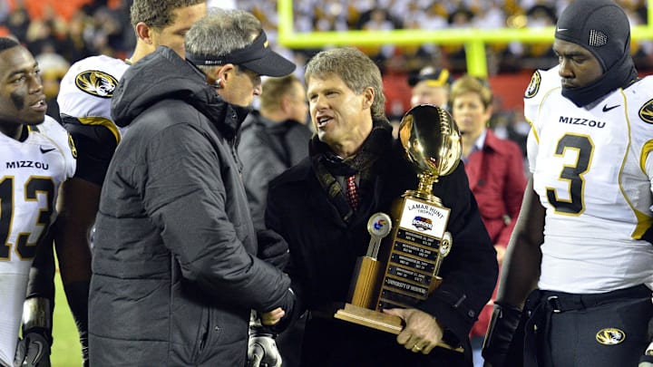 November 26, 2011; Kansas City, MO, USA; Kansas City Chiefs owner Clark Hunt presents the Lamar Hunt trophy to Missouri Tigers head coach Gary Pinkel after the Tigers defeated the Kansas Jayhawks 24-10 at Arrowhead Stadium. Mandatory Credit: Denny Medley-Imagn Images