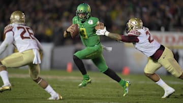Jan 1, 2015; Pasadena, CA, USA; Oregon Ducks quarterback Marcus Mariota (8) is defended by Florida State Seminoles cornerback P.J. Williams (26) and defensive end Chris Casher (21) on a 23-yard touchdown run in the fourth quarter in the 2015 Rose Bowl college football game at Rose Bowl. Oregoon defeated Florida State 59-20. Mandatory Credit: Kirby Lee-Imagn Images