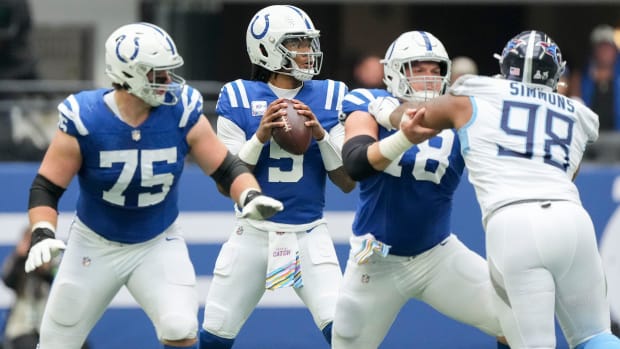 Colts quarterback Anthony Richardson (blue jersey with white helmet) stands behind his protection from the defense.