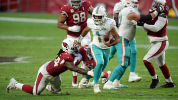 Miami Dolphins quarterback Tua Tagovailoa (1) breaks the tackle of Arizona Cardinals linebacker Markus Golden (44) and Arizona Cardinals cornerback Byron Murphy (33) during the second half at State Farm Stadium in 2020.