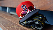A detailed view of a Boston Red Sox cap, sunglasses and glove in the dugout  during a spring training game between the Washington Nationals and the Boston Red Sox at FITTEAM Ballpark of the Palm Beaches in West Palm Beach, Fla.