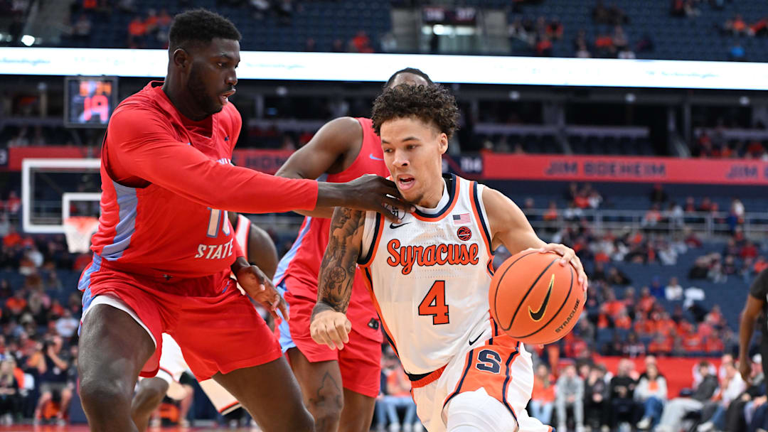 Nov 8, 2025; Syracuse, New York, USA; Syracuse Orange guard Nate Kingz (4) drives the ball as Delaware State Hornets forward Cyril Obasogie (10) defends in the second half at the JMA Wireless Dome. Mandatory Credit: Mark Konezny-Imagn Images