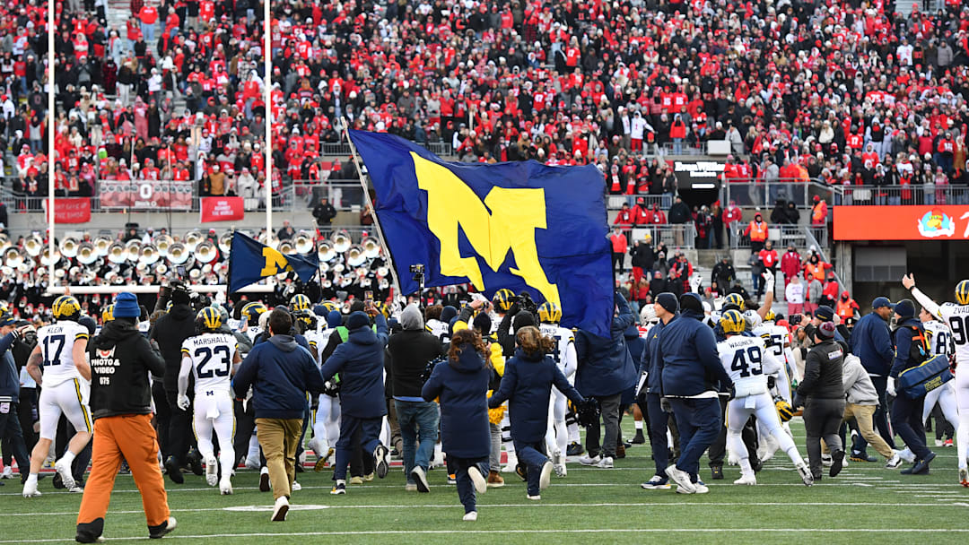 Michigan players carrying team flag after 13-10 win over rival Ohio State, Nov. 30th, 2024