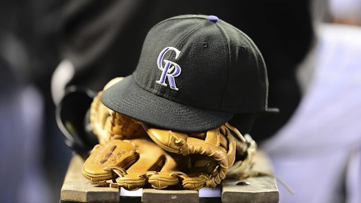 Jul 7, 2014; Denver, CO, USA; General view of a Colorado Rockies cap and glove in the seventh inning against the San Diego Padres at Coors Field. Mandatory Credit: Ron Chenoy-Imagn Images