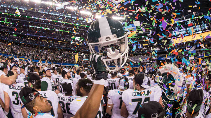 Jan 1, 2015; Arlington, TX, USA; A Michigan State Spartans player holds up his helmet as his team celebrates the win over the Baylor Bears in the 2015 Cotton Bowl Classic at AT&T Stadium. The Spartans defeated the Bears 42-41. Mandatory Credit: Jerome Miron-USA TODAY Sports