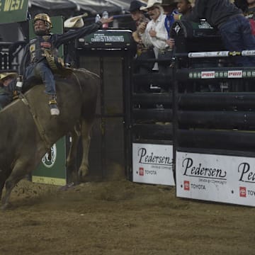 A rider attempts to stay on the bull during night one of PBR's Last Cowboy Standing showcase event on July 21, 2025 at CSU's Canvas Stadium in Fort Collins, Colo.