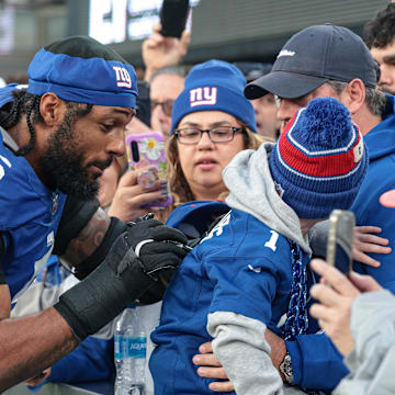 Dec 29, 2024; East Rutherford, New Jersey, USA; New York Giants linebacker Kayvon Thibodeaux (5) signs an autograph after the game against the Indianapolis Colts at MetLife Stadium.  