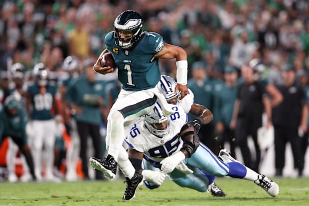 Philadelphia Eagles quarterback Jalen Hurts avoids a tackle by Dallas Cowboys defensive tackle Kenny Clark.