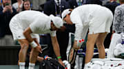 Jannik Sinner helps Grigor Dimitrov pack his things after retiring for a medical issue.