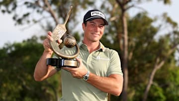 Viktor Hovland holds the winner's trophy following his victory at the 2025 Valspar Championship