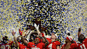 Dec 7, 2024; Atlanta, GA, USA; The Georgia Bulldogs celebrate with the trophy after defeating the Texas Longhorns in overtime in the 2024 SEC Championship game at Mercedes-Benz Stadium.