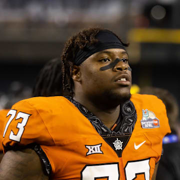 Dec 27, 2022; Phoenix, Arizona, USA; Oklahoma State Cowboys offensive lineman Jason Brooks Jr. (73) against the Wisconsin Badgers during the 2022 Guaranteed Rate Bowl at Chase Field. Mandatory Credit: Mark J. Rebilas-Imagn Images