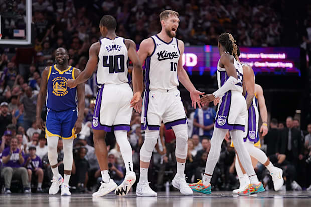 Sacramento Kings forward Domantas Sabonis (10) reacts next to Harrison Barnes (40) and Keon Ellis (23). 