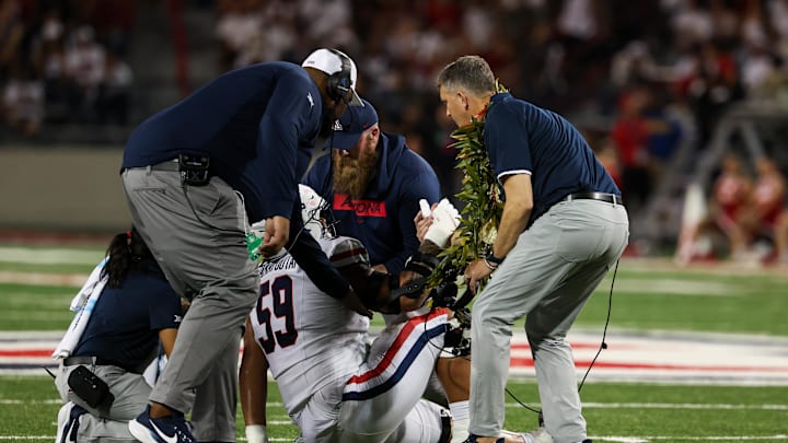 Aug 31, 2024; Tucson, Arizona, USA; Arizona Wildcats offensive lineman Rhino Tapa’atoutai (59) gets helped up after injury by Arizona Wildcats head coach Brent Brennan during third quarter at Arizona Stadium. Mandatory Credit: Aryanna Frank-Imagn Images