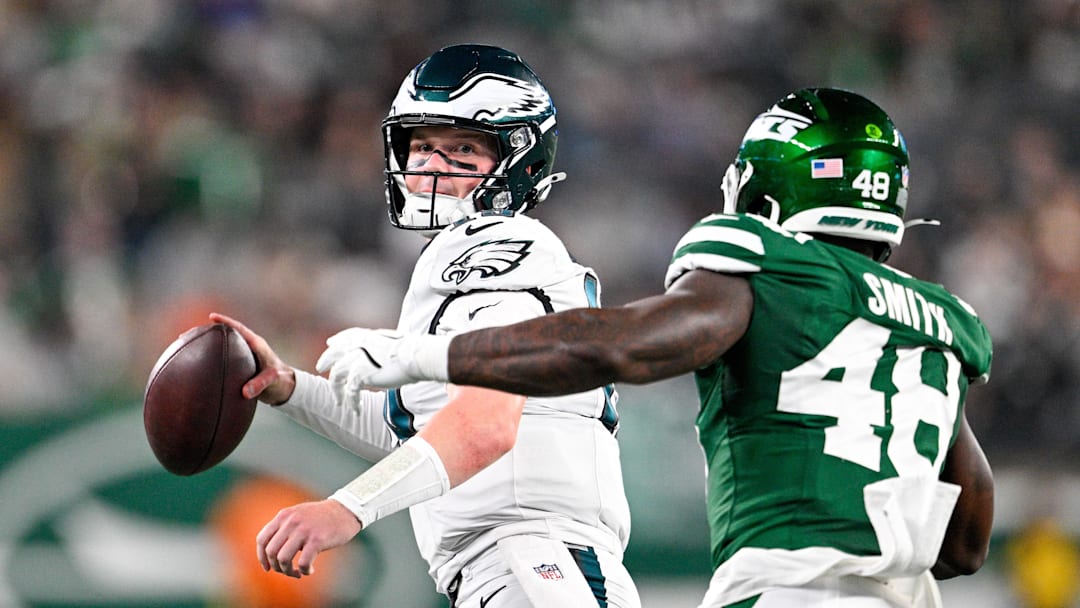 Aug 22, 2025; East Rutherford, New Jersey, USA; Philadelphia Eagles quarterback Kyle McCord (19) looks to pass the ball chased by New York Jets linebacker Boog Smith (48) during the third quarter at MetLife Stadium. Mandatory Credit: Mark Smith-Imagn Images