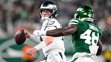 Philadelphia Eagles quarterback Kyle McCord (19) looks to pass the ball, chased by New York Jets linebacker Boog Smith (48) during the third quarter at MetLife Stadium.