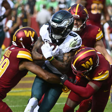 Oct 29, 2023; Landover, Maryland, USA; Philadelphia Eagles wide receiver DeVonta Smith (6) is tackled by Washington Commanders cornerback Benjamin St-Juste (25) and cornerback Kendall Fuller (29) during the first half at FedExField. Mandatory Credit: Brad Mills-USA TODAY Sports