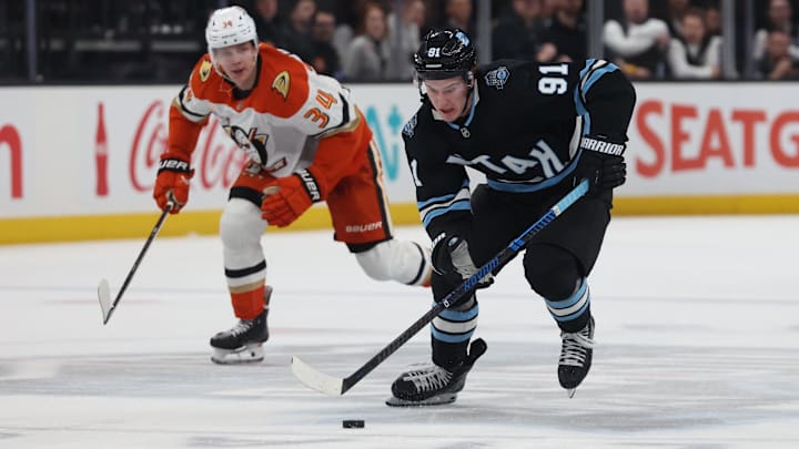 Mar 12, 2025; Salt Lake City, Utah, USA; Utah Hockey Club right wing Josh Doan (91) skates with the puck against Anaheim Ducks defenseman Pavel Mintyukov (34) during the second period at Delta Center. Mandatory Credit: Rob Gray-Imagn Images