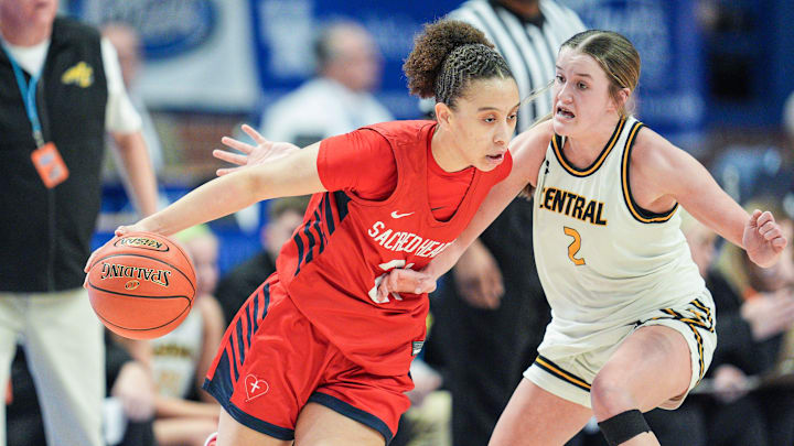 Sacred Heart's Brianna Wilkins (21) looks to drive past Johnson Central's Allie Slone (2) battle for control in the first half Thursday during the 2025 Clark’s Pump-N-Shop Girls’ Basketball Sweet 16 in Rupp Arena in Lexington, Kentucky. March 13, 2025