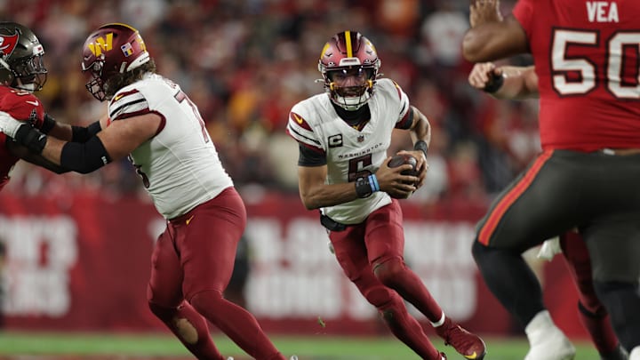 Jan 12, 2025; Tampa, Florida, USA; Washington Commanders quarterback Jayden Daniels (5) scrambles during the second quarter of a NFC wild card playoff against the Tampa Bay Buccaneers at Raymond James Stadium. Mandatory Credit: Nathan Ray Seebeck-Imagn Images