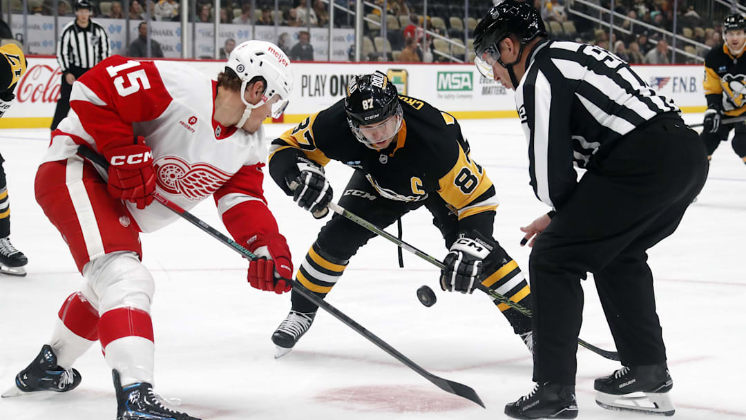 Detroit Red Wings center Sheldon Dries (15) and Pittsburgh Penguins center Sidney Crosby (87) take a face-off in an presaosn game at PPG Paints Arena. 