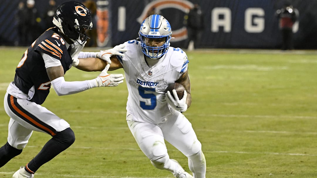 Jan 4, 2026; Chicago, Illinois, USA; Detroit Lions running back David Montgomery (5) runs with the ball against Chicago Bears cornerback Nahshon Wright (26) during the second half at Soldier Field. Mandatory Credit: Matt Marton-Imagn Images