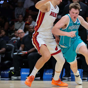 Oct 28, 2025; Miami, Florida, USA; Charlotte Hornets guard Kon Knueppel (7) drives to the basket against Miami Heat forward Nikola Jovic (5) during the second quarter at Kaseya Center. Mandatory Credit: Sam Navarro-Imagn Images