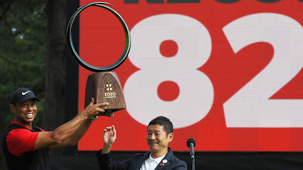 Tiger Woods receives a victory trophy from Yusaku Maezawa, the founder of Zozo, after the 2019 Zozo Championship.
