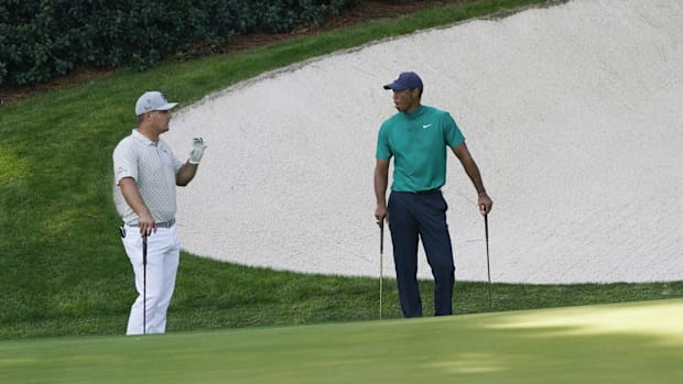 Bryson DeChambeau (left) and Tiger Woods talk on the 13th green during a practice round for the 2020 Masters.