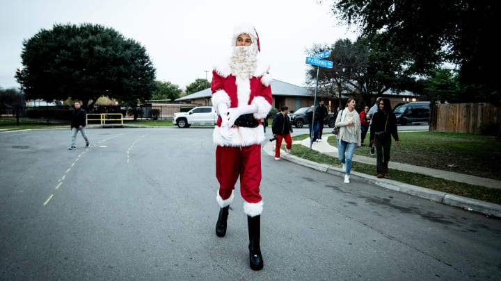 Dec 14, 2024; San Antonio, TX, USA; San Antonio Spurs star Victor Wembanyama (1) walks down the street in a Santa Claus costume as part of a community partnership with Elf Louise. 