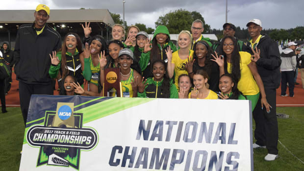 Members of the Oregon Ducks women's team and coach Robert Johnson pose after winning the team title during the NCAA Track and