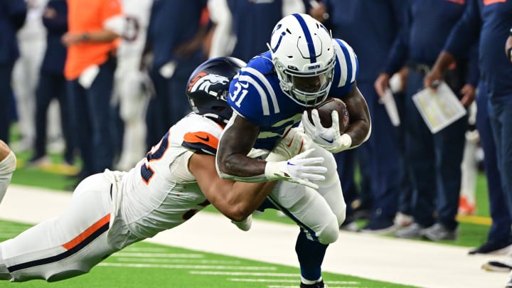 Aug 11, 2024; Indianapolis, Indiana, USA;  Indianapolis Colts running back Tyler Goodson (31) is tackled by Denver Broncos linebacker Jonah Elliss (52) during the first quarter at Lucas Oil Stadium. 