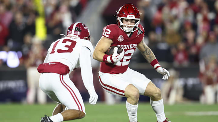Dec 19, 2025; Norman, OK, USA; Oklahoma Sooners tight end Jaren Kanak (12) attempts to elude a tackle by Alabama Crimson Tide defensive back Ivan Taylor (13) in the first half at Gaylord Family OK Memorial Stadium. Mandatory Credit: Mark J. Rebilas-Imagn Images